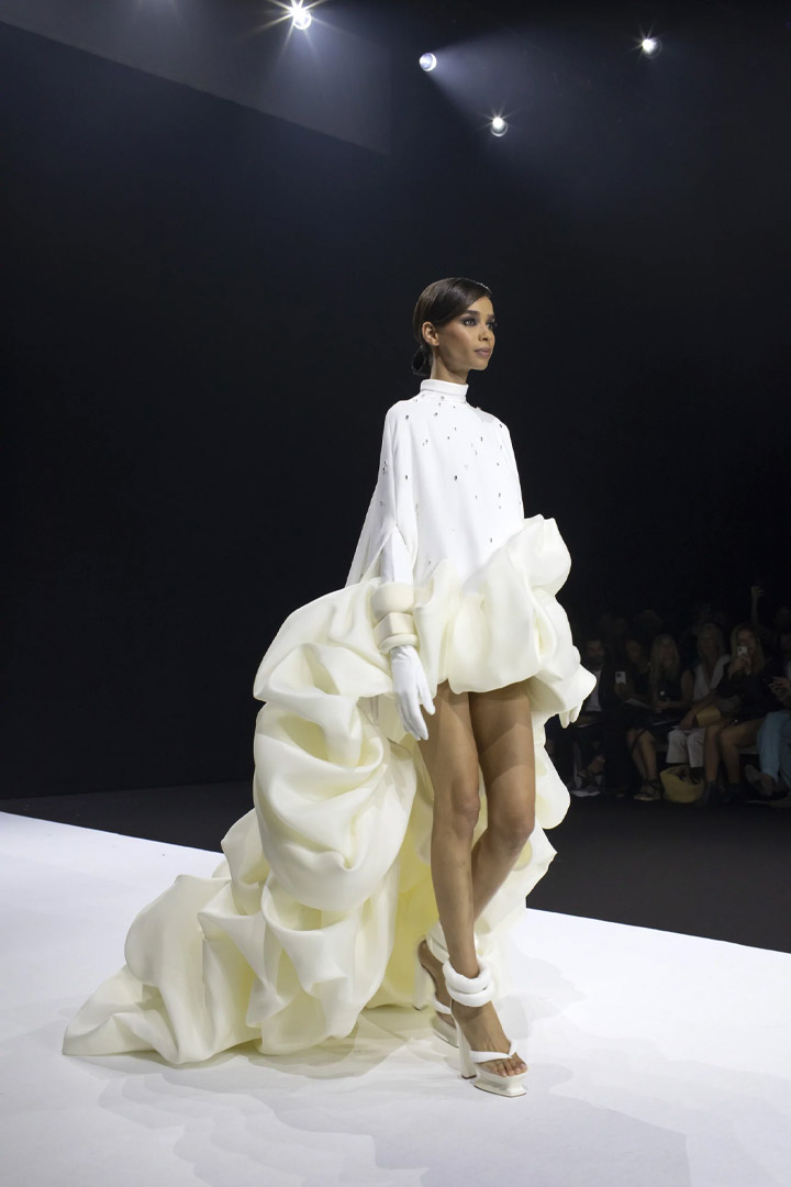 N°29 - LONG ASYMMETRICAL PONCHO IN WHITE GRAINY CREPE EMBROIDERED WITH CRYSTAL. SCULPTURES IN WHITE GAZAR FROM STÉPHANE ROLLAND HAUTE COUTURE COLLECTION - AUTUMN-WINTER 2022-2023 HAUTE COUTURE WEEK